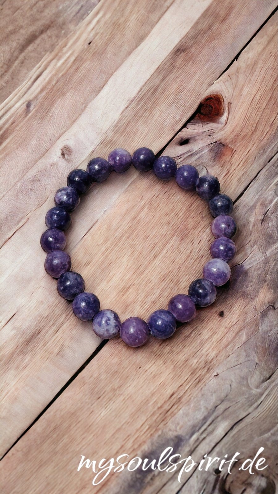 Lepidolith Armband aus 6 mm Perlen auf einem antiken Holzbrett. Lepidolith ist lila-weiss.