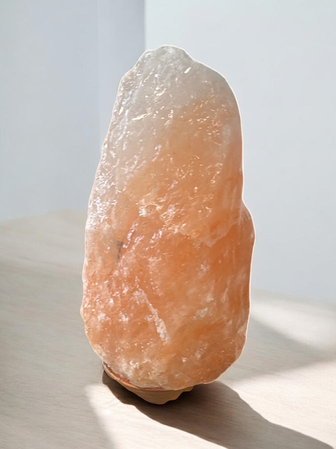 Himalaya Salzlampe auf hellem Tisch vor weißem Hintergrund