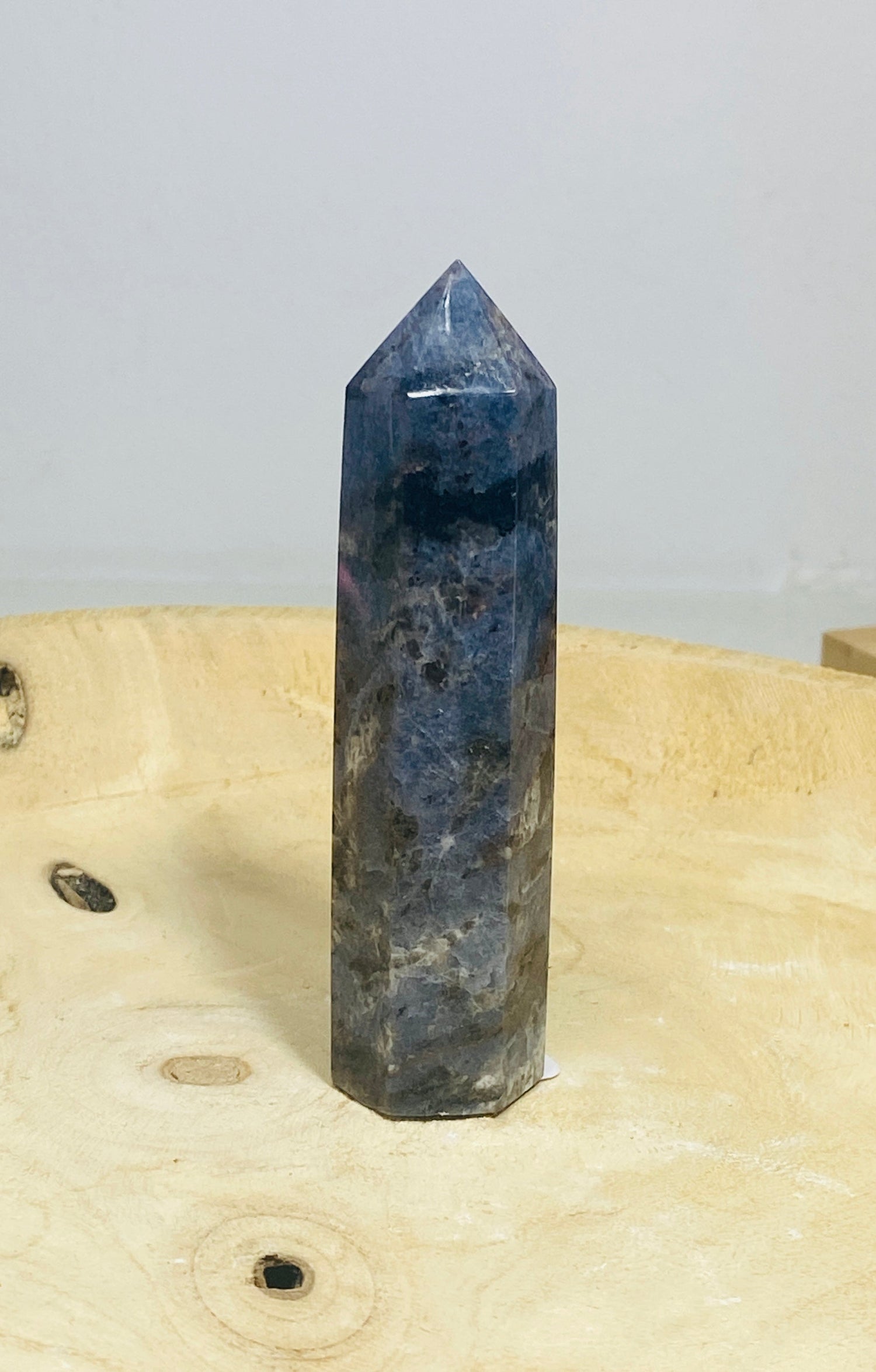 Sodalith Turm mit schwarz-blauer Maserung auf einem Holzbrett