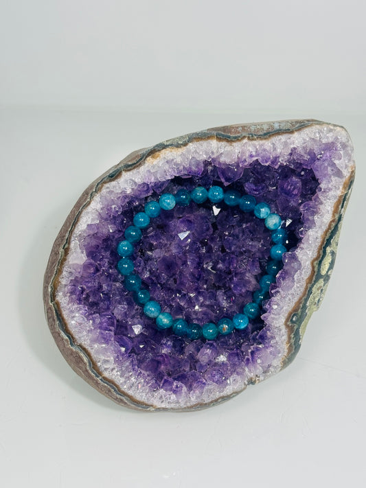 Apatit Armband mit hellblauen Perlen in einer Amethyst-Druse zum Aufladen des Armbands.